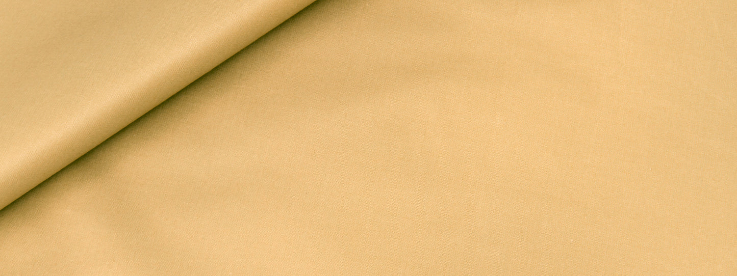 Beige fabric with a rolled edge and soft diagonal fold; smooth warm-toned textile.