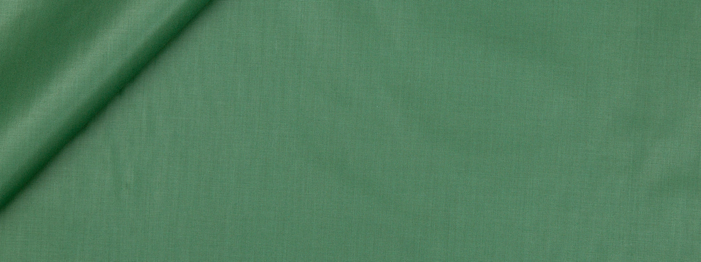 Emerald green fabric with a subtle weave and diagonal fold; versatile for sewing projects.