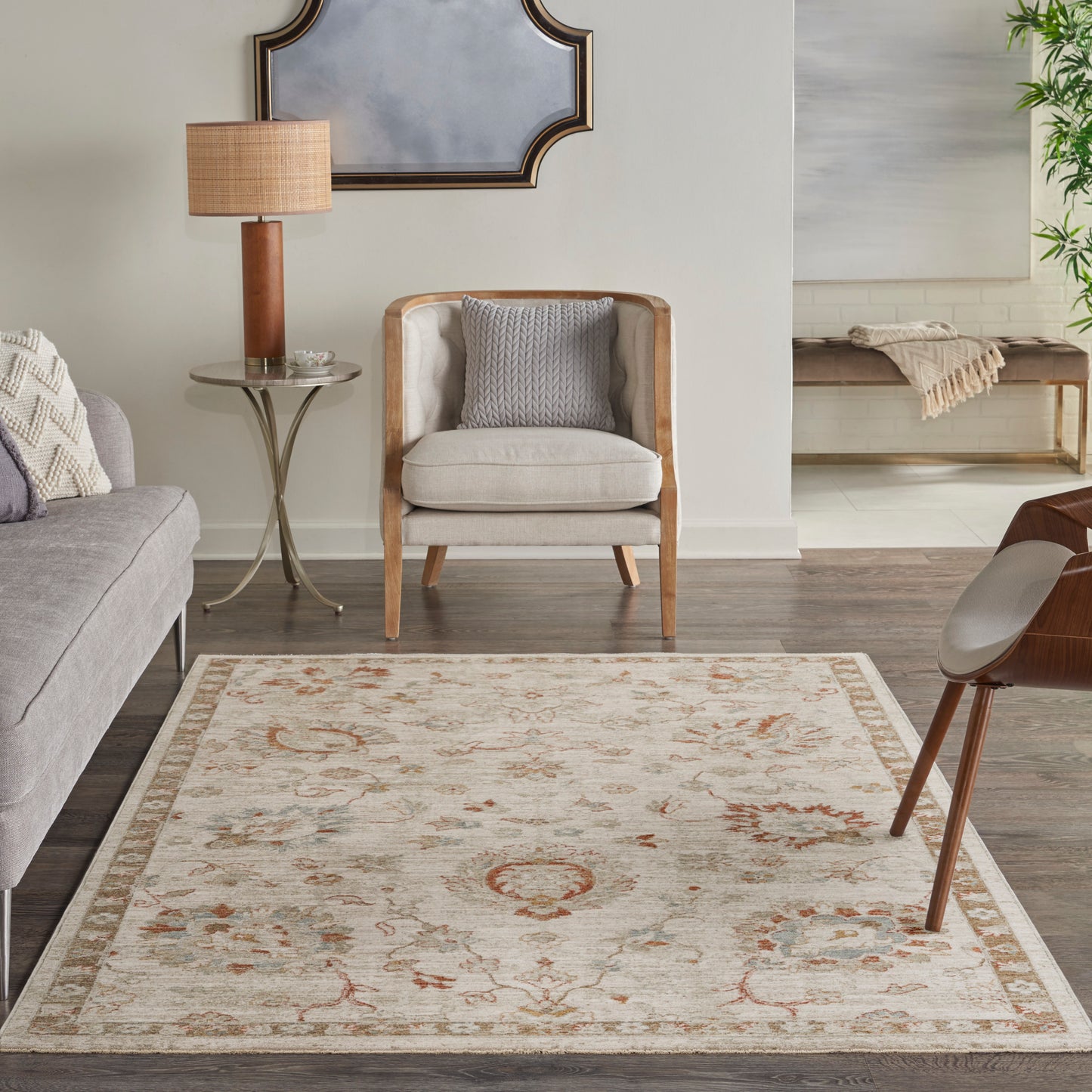 Cream oriental-style rug with floral border in a neutral living room, paired with light-wood furniture and grey upholstery.