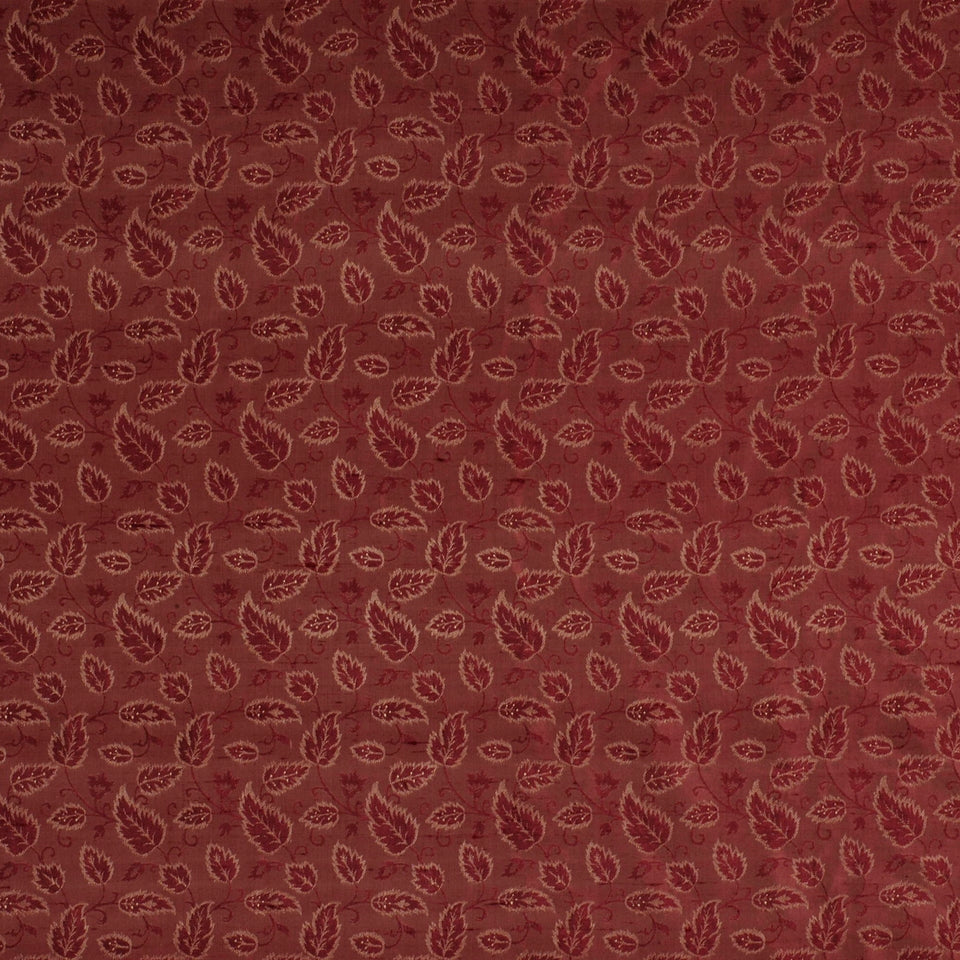 Burgundy fabric with a dense tan leaf motif pattern; a soft woven textile suitable for upholstery or apparel.
