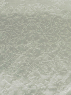 Soft pale sage-green fabric with a subtle white damask floral scroll pattern.