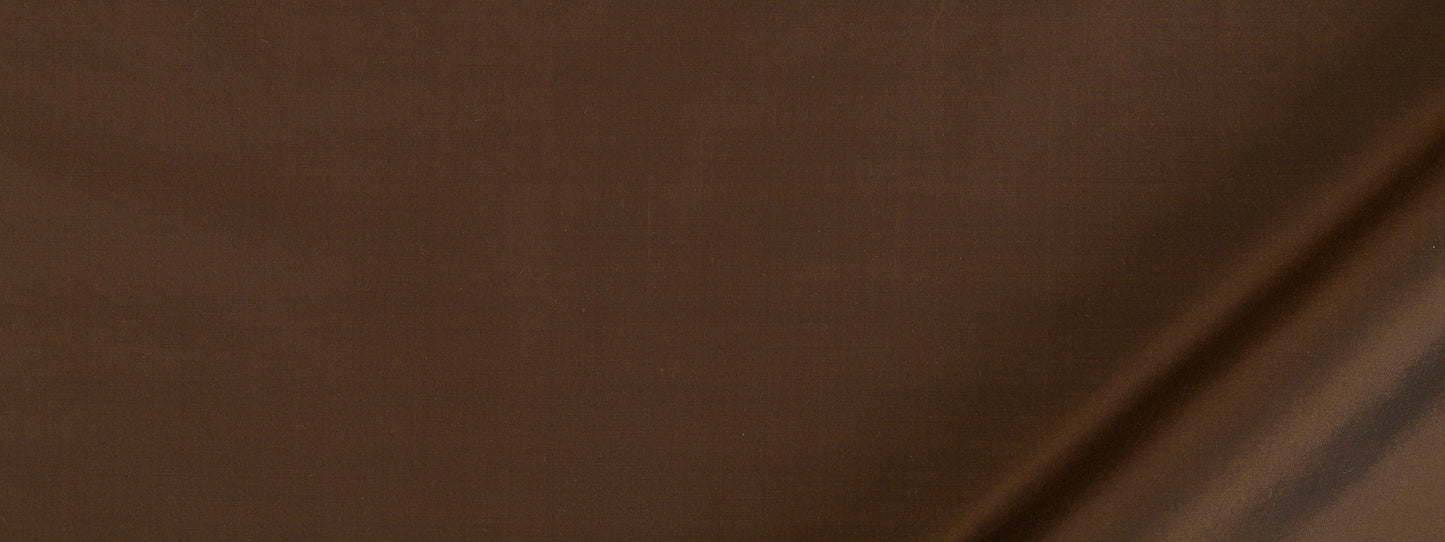 Close-up of warm brown textured fabric with a diagonal seam.