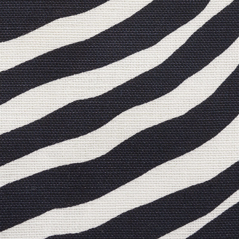Close-up of zebra-striped black & white woven fabric showing bold pattern and textured surface.