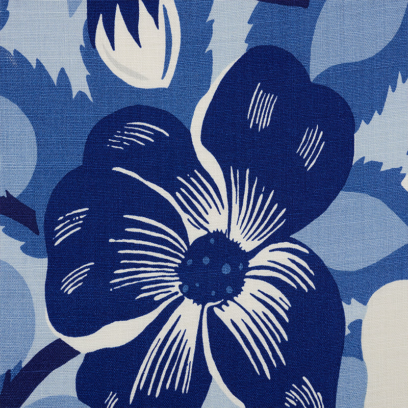 Blue floral textile featuring a bold navy flower with white highlights on a pale blue background.