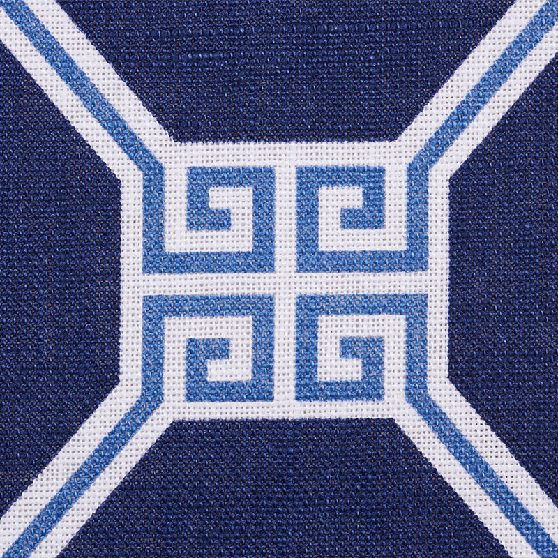 Close-up of navy blue woven fabric featuring white & light-blue Greek-key cross motif.