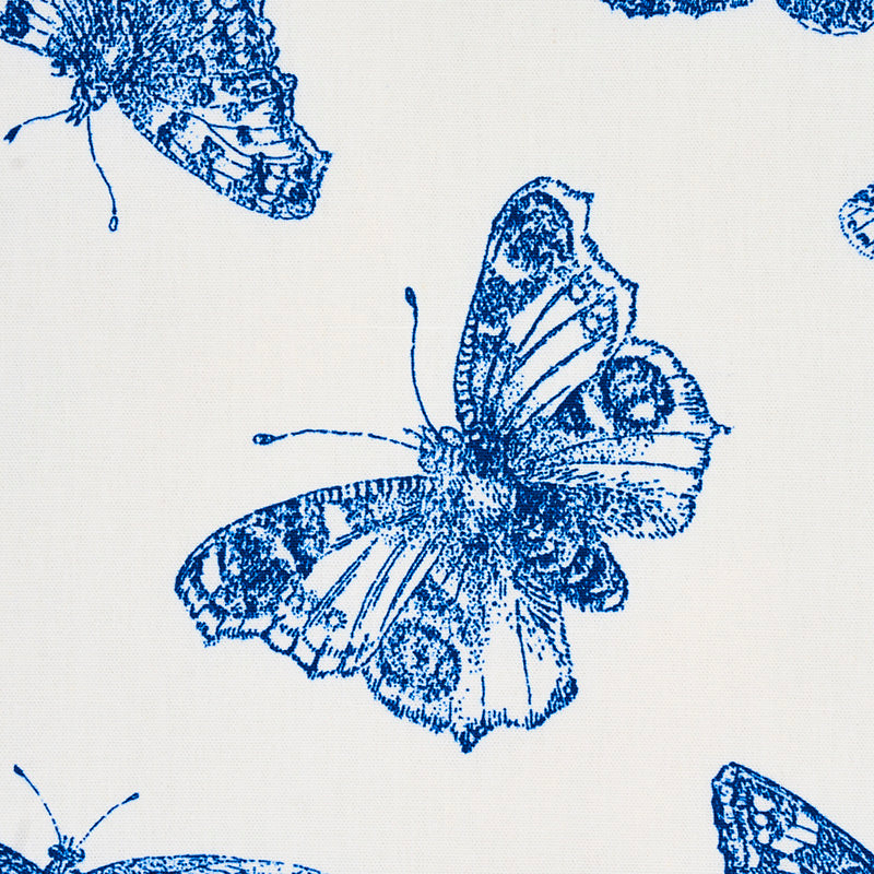 Blue butterfly print on ivory fabric with detailed wings; decorative textile for upholstery or curtains.