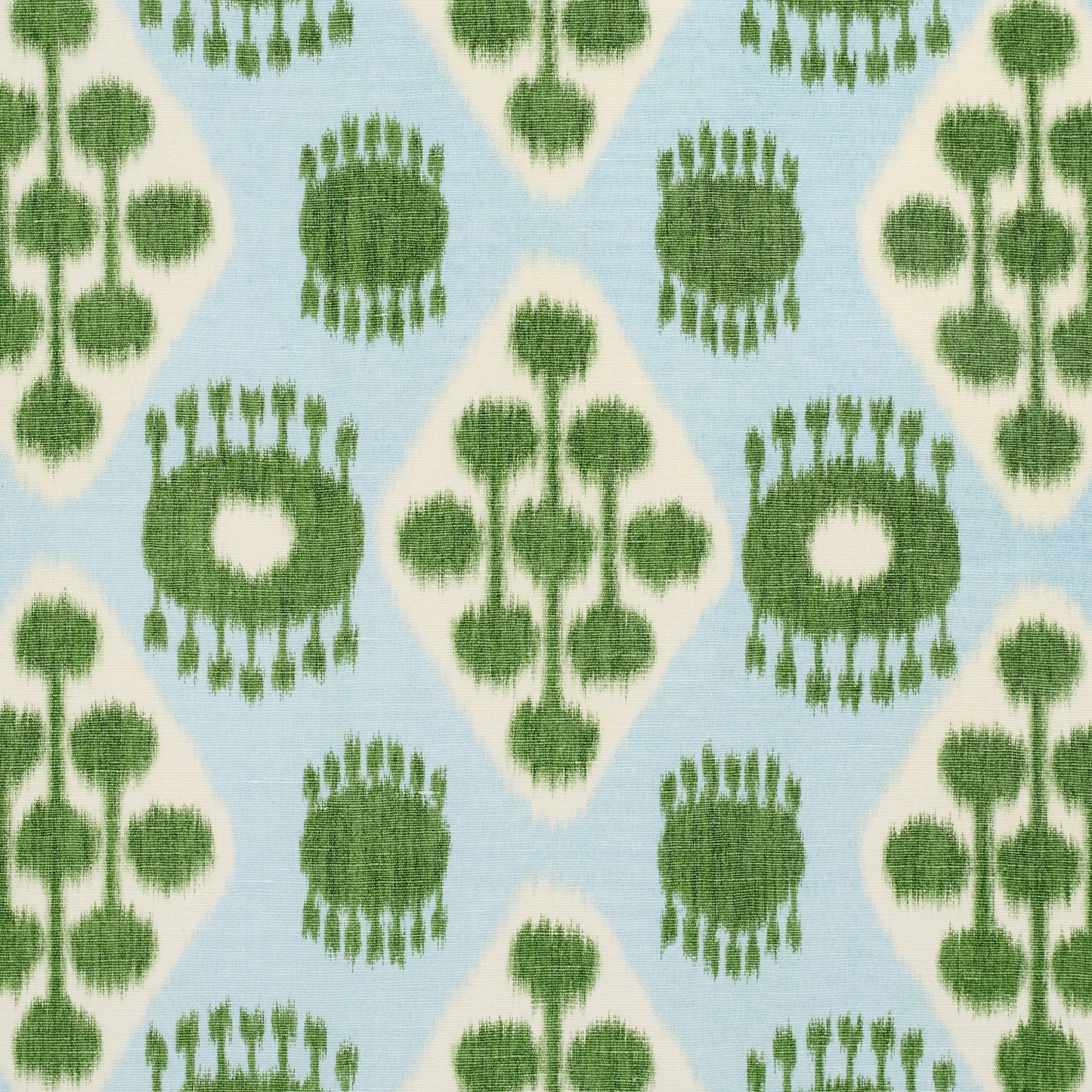 Ikat-inspired green circular motifs and diamond shapes on pale blue fabric.