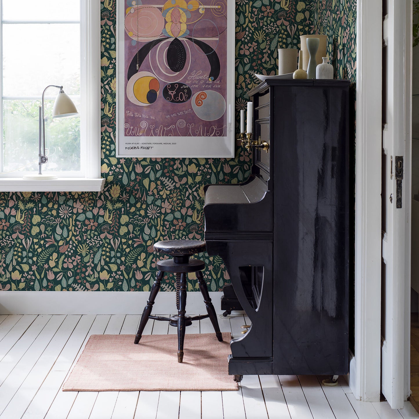 Green botanical wallpaper with a leafy pattern on the wall.