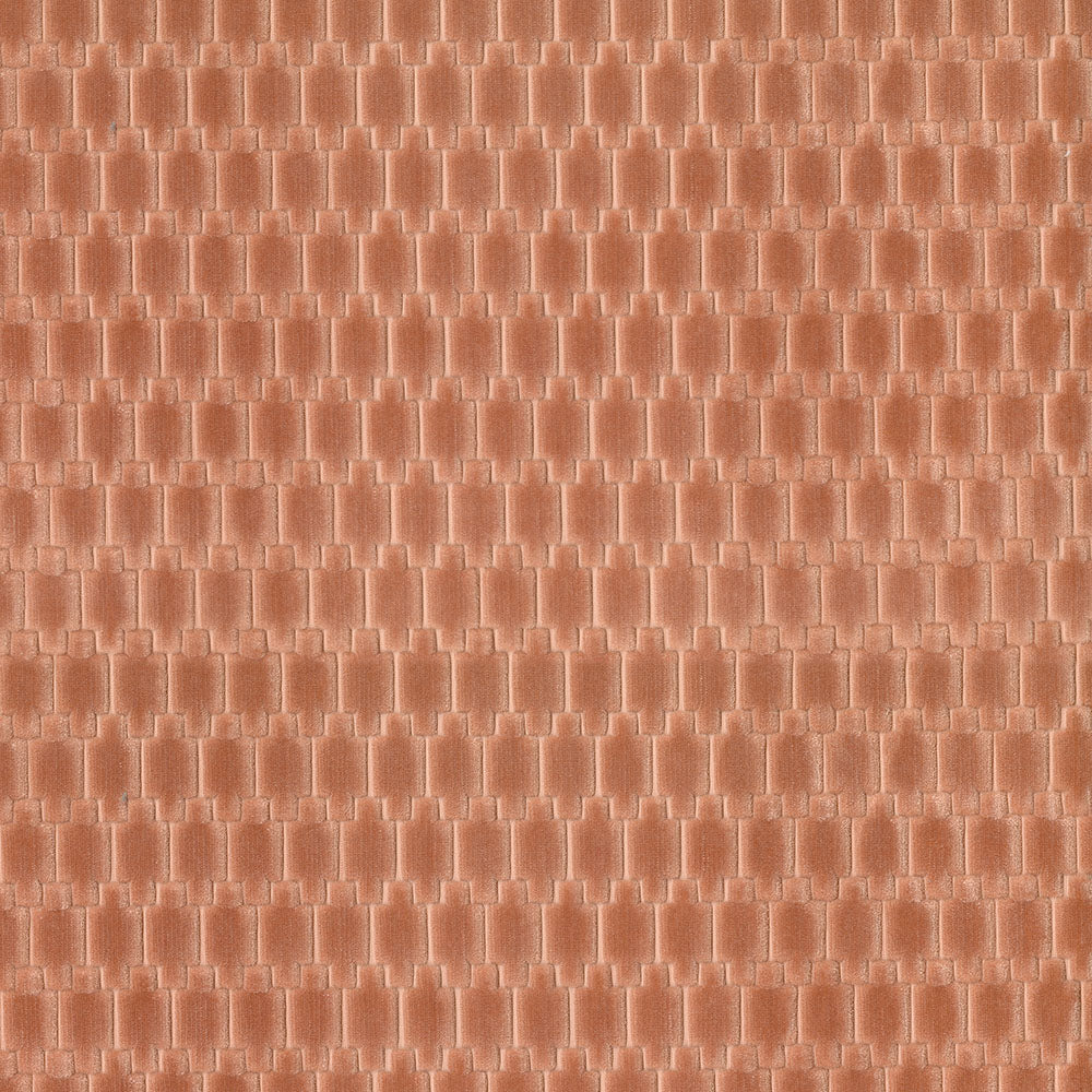 Peach velvet fabric close-up with a repeating geometric pattern.