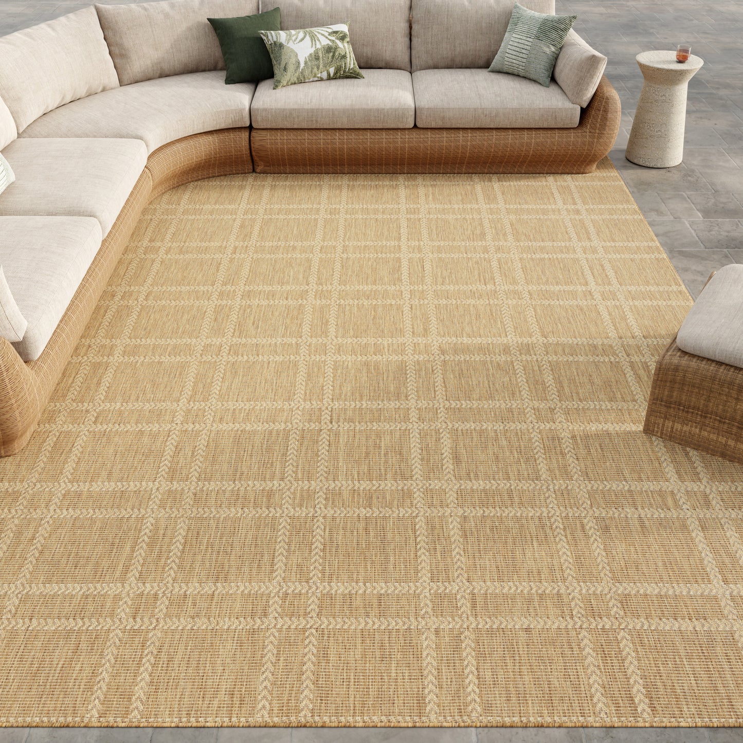Beige woven natural-fiber area rug with a plaid grid in a modern living room beside a curved cream sectional.