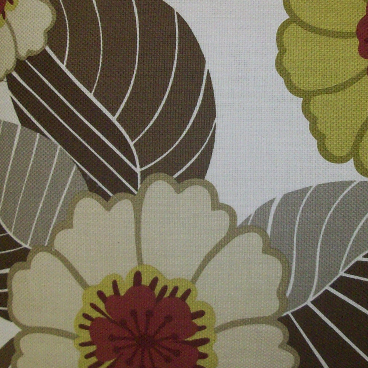 Large cream flower with red center and yellow accents on brown, olive, and gray leaves - bold tropical floral pillow.