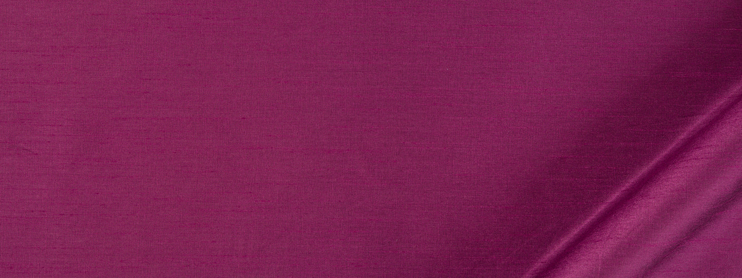 Magenta satin fabric with glossy sheen and soft draped fold, luxurious textile.