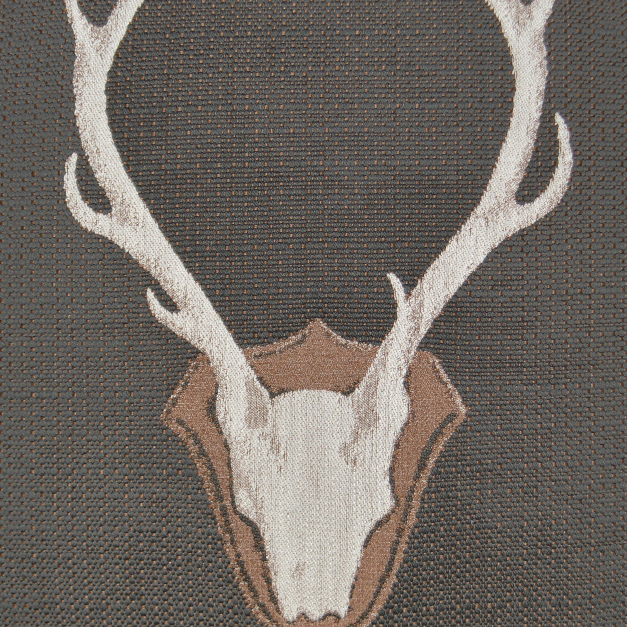 Grey pillow featuring a white deer skull with antlers and a tan shield outline on woven fabric.