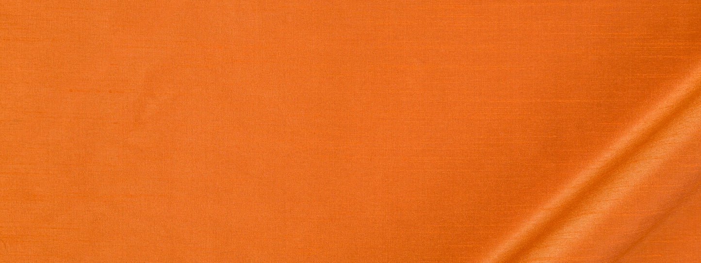 Orange satin fabric with subtle sheen and a diagonal fold at the bottom right.