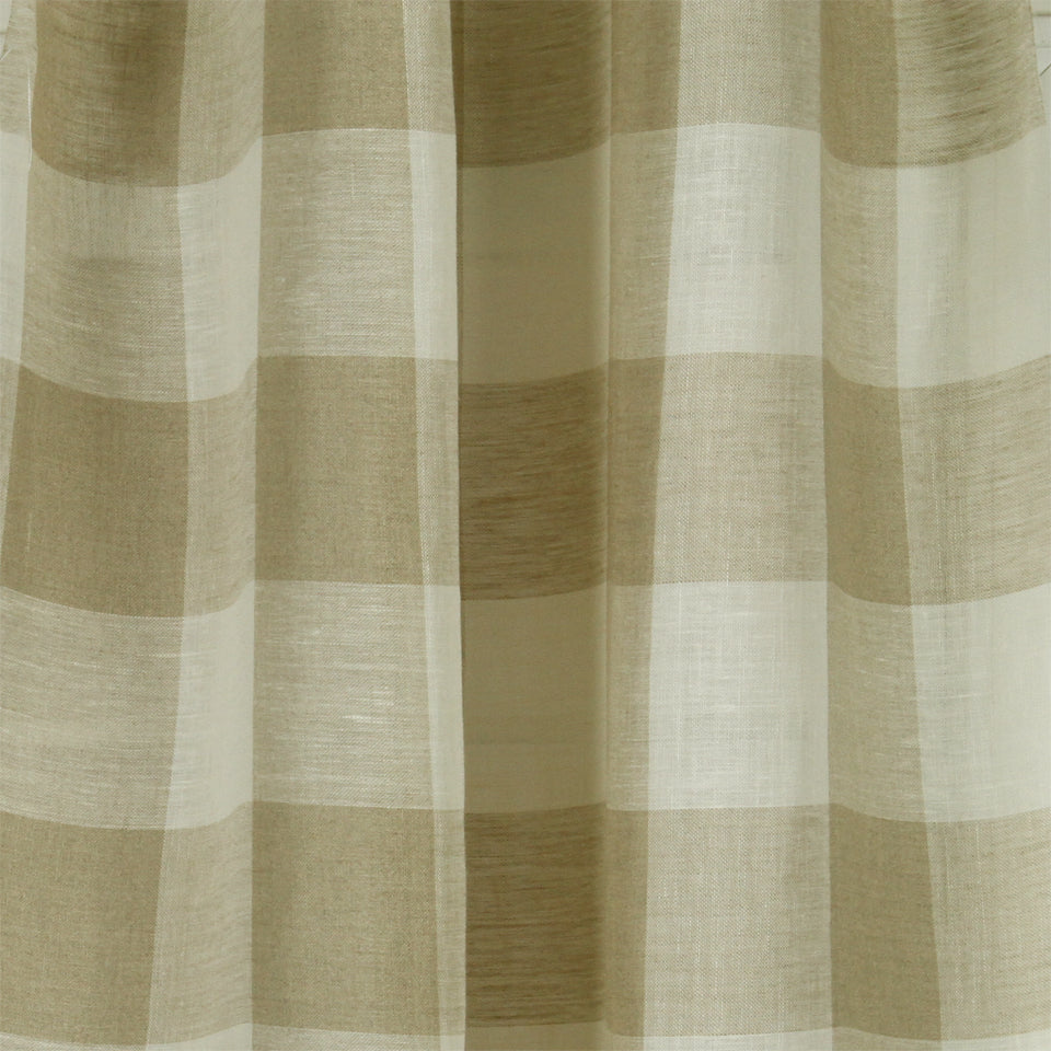 Beige and cream large checkered curtain fabric with linen texture, draped in soft folds.
