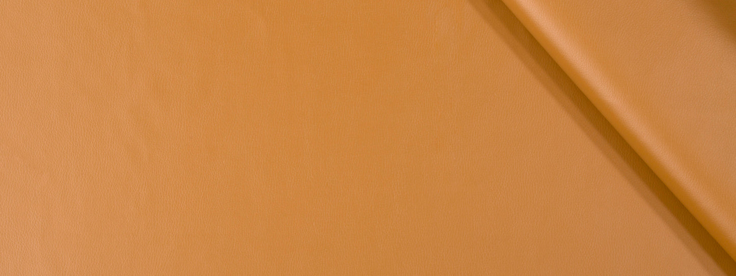 Close-up of camel-toned upholstery fabric texture with a diagonal seam, warm color and minimal style.