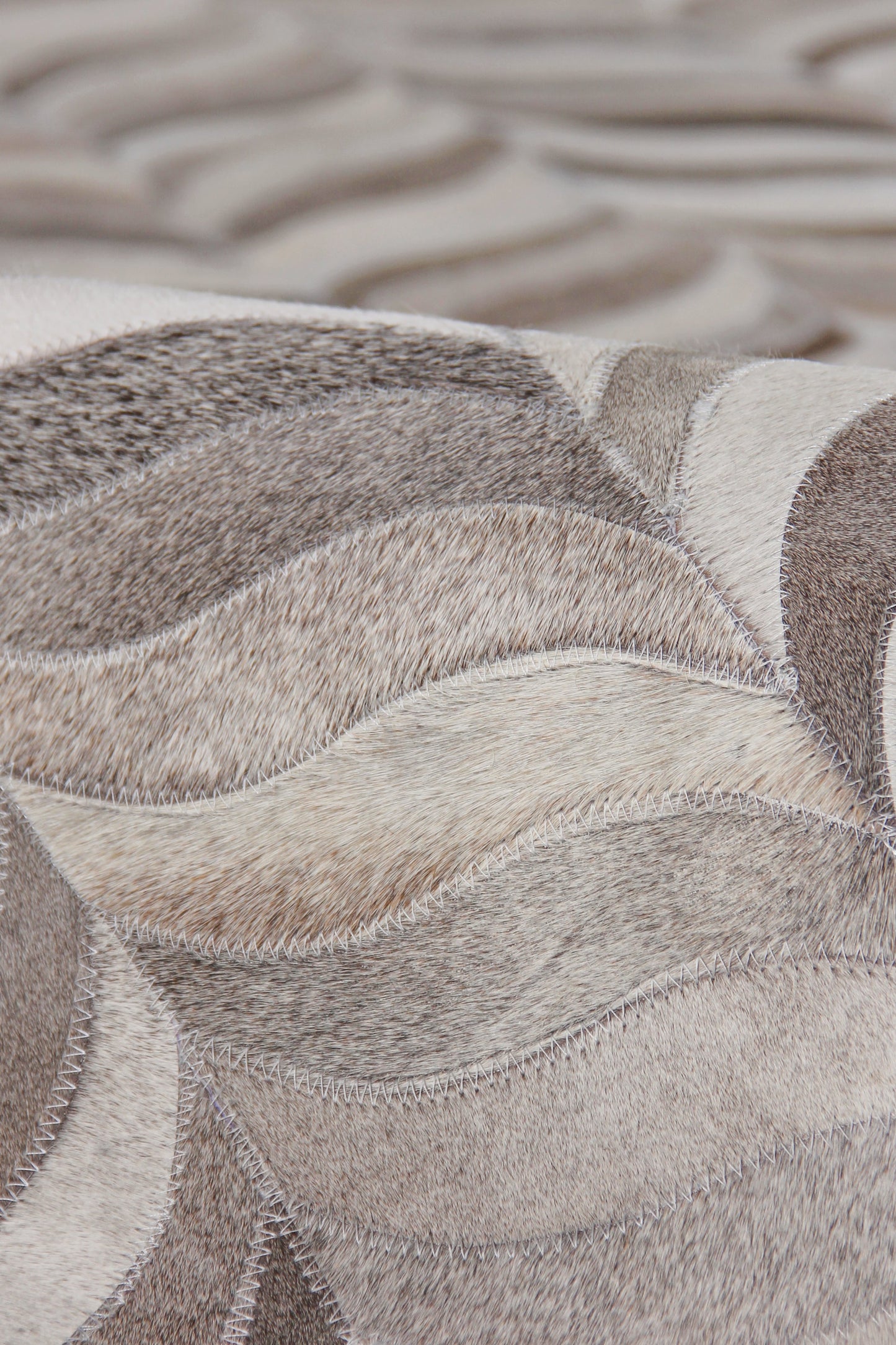 Natural hide indoor hand-stitched rug, 5' x 7'.