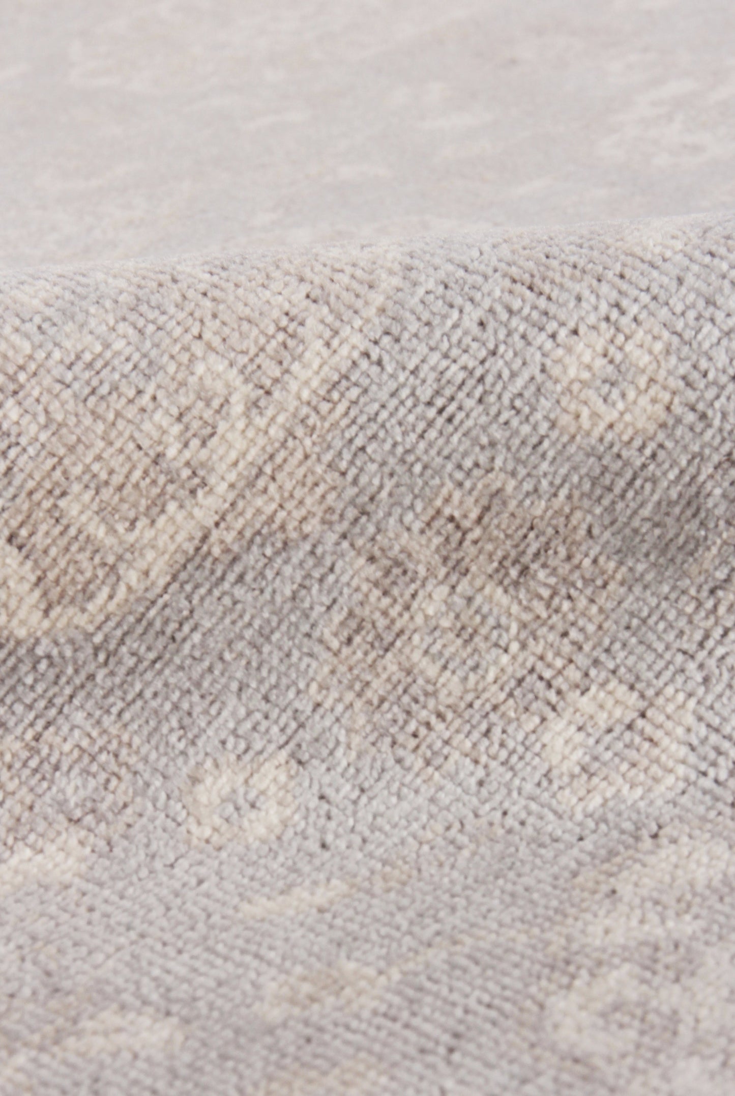 Beige-gray woven rug close-up with a soft textured pile and subtle diamond pattern.