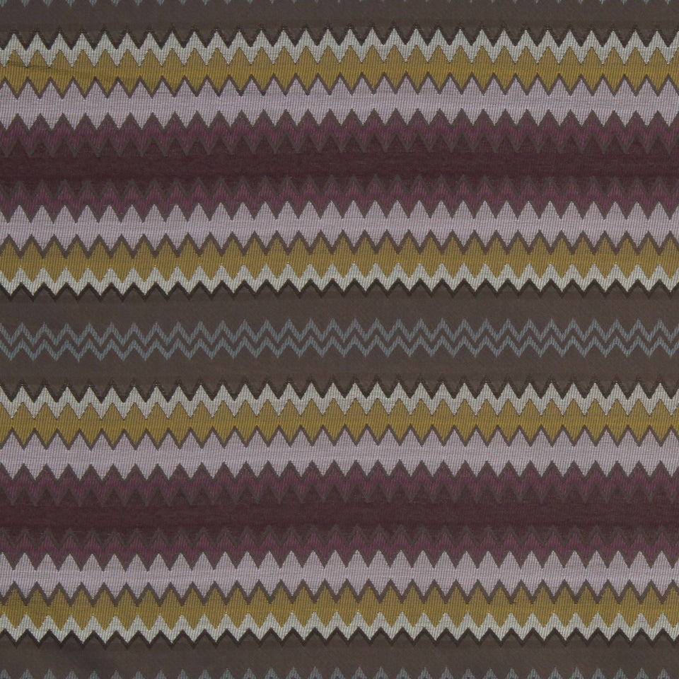 Chevron zigzag stripe fabric in maroon, mustard, lavender, pale pink and gray; dense repeating pattern.