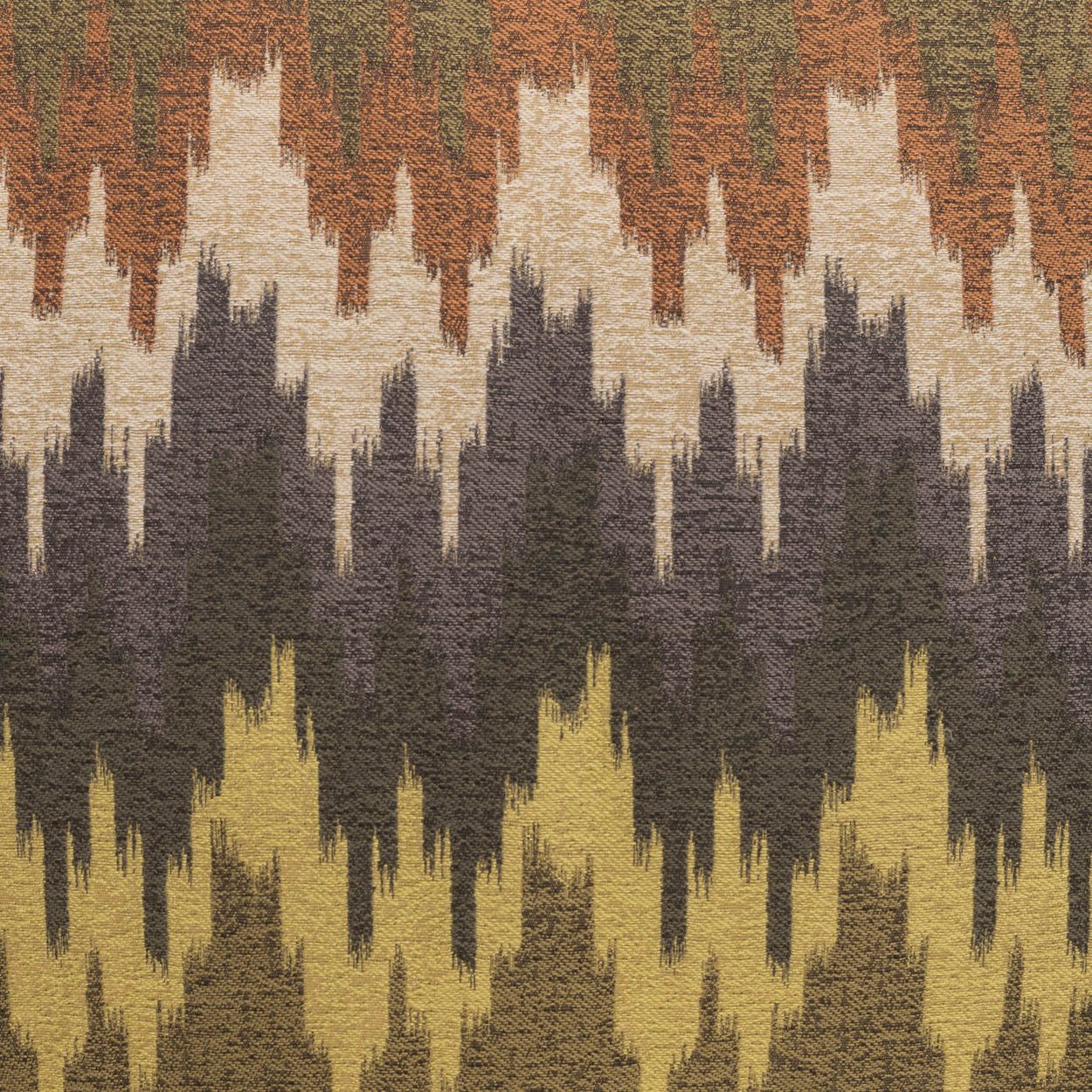 Woven fabric with jagged ikat chevrons in autumn hues: orange, olive, beige, charcoal, and mustard.