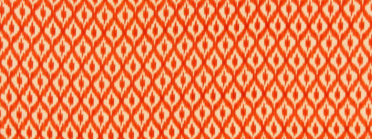 Orange and white geometric ikat-patterned fabric with repeated diamond motifs.