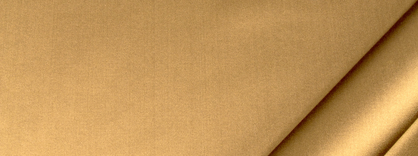 Tan beige fabric close-up with a diagonal crease and subtle woven texture.