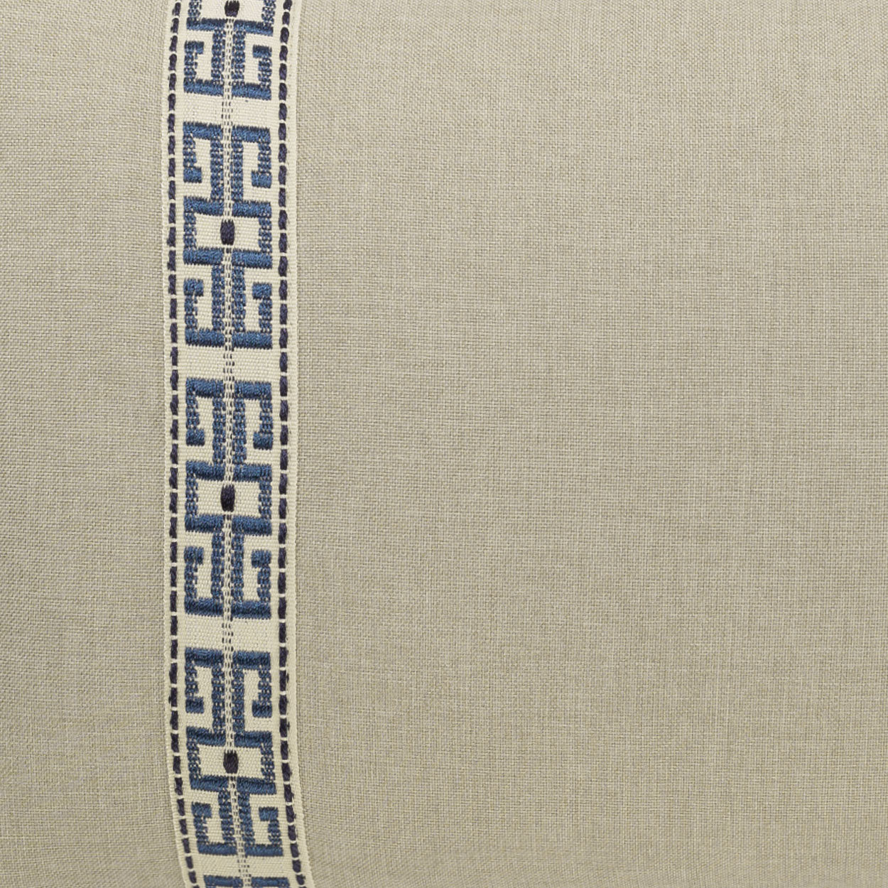 Beige linen-like lumbar pillow with a vertical blue Greek-key trim along the left edge.