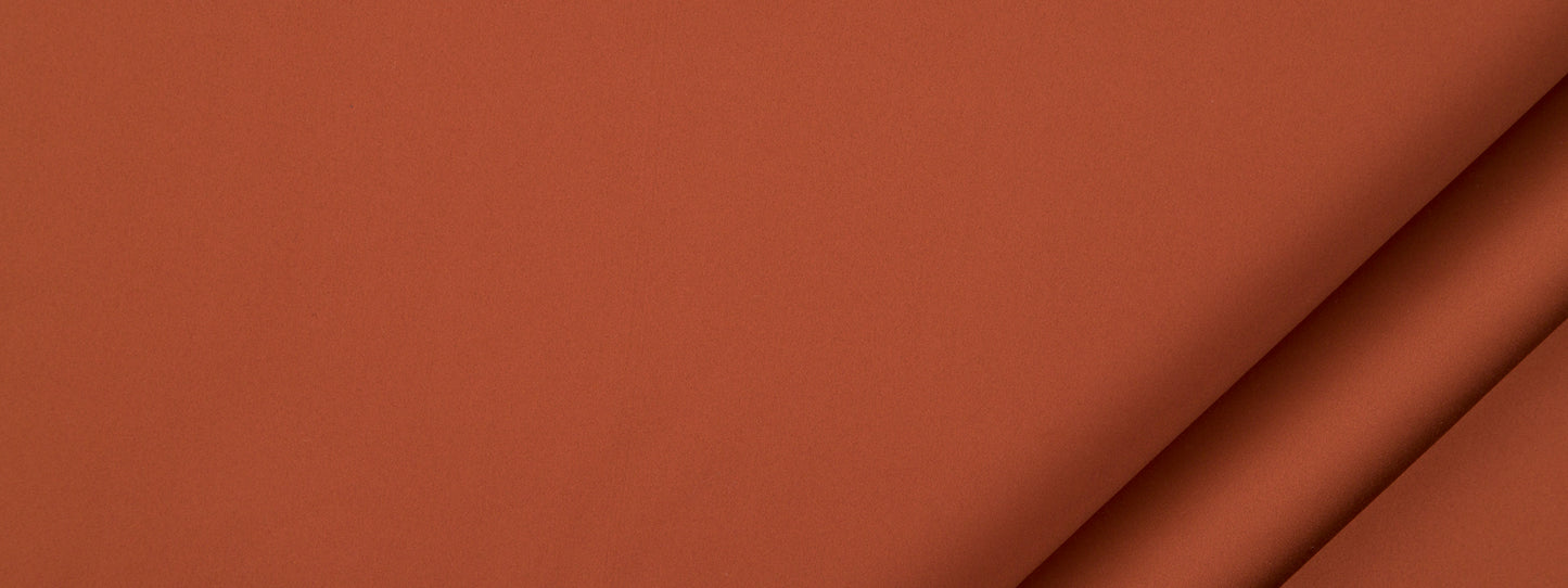 Burnt orange fabric swatch with a smooth finish and rolled edge.