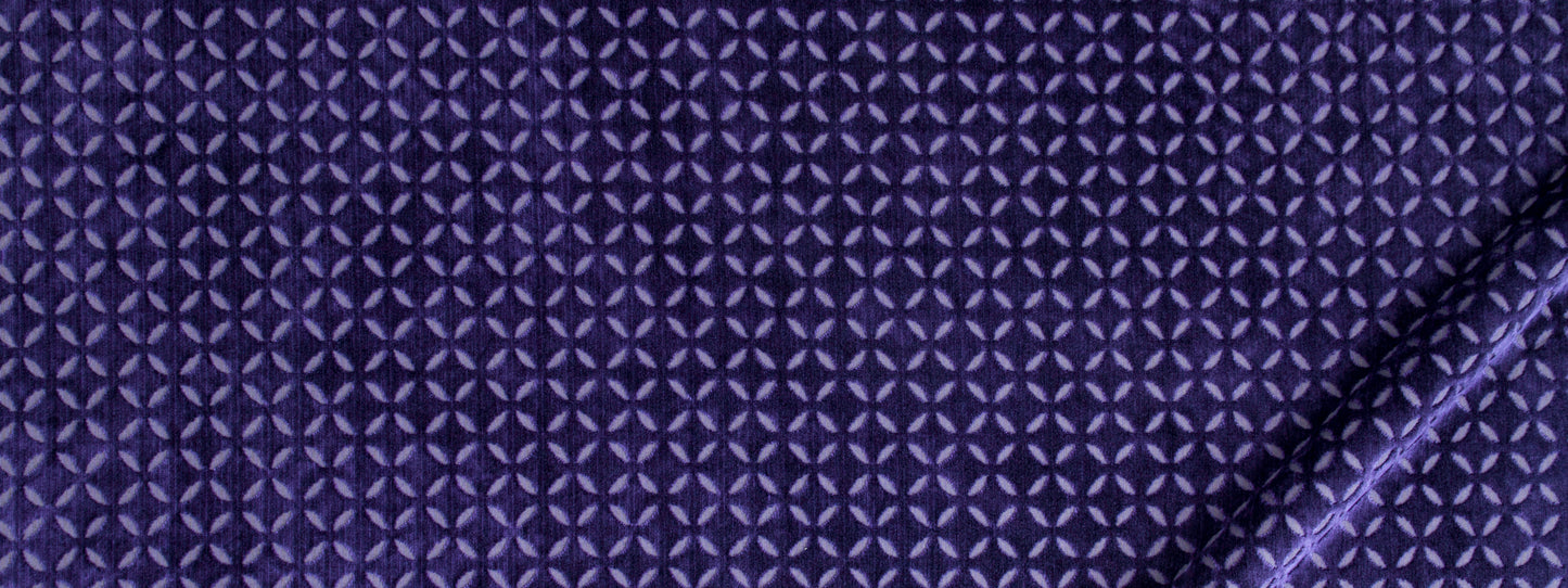 Deep purple fabric with tiny light-purple star-like geometric pattern, folded edge on the right.