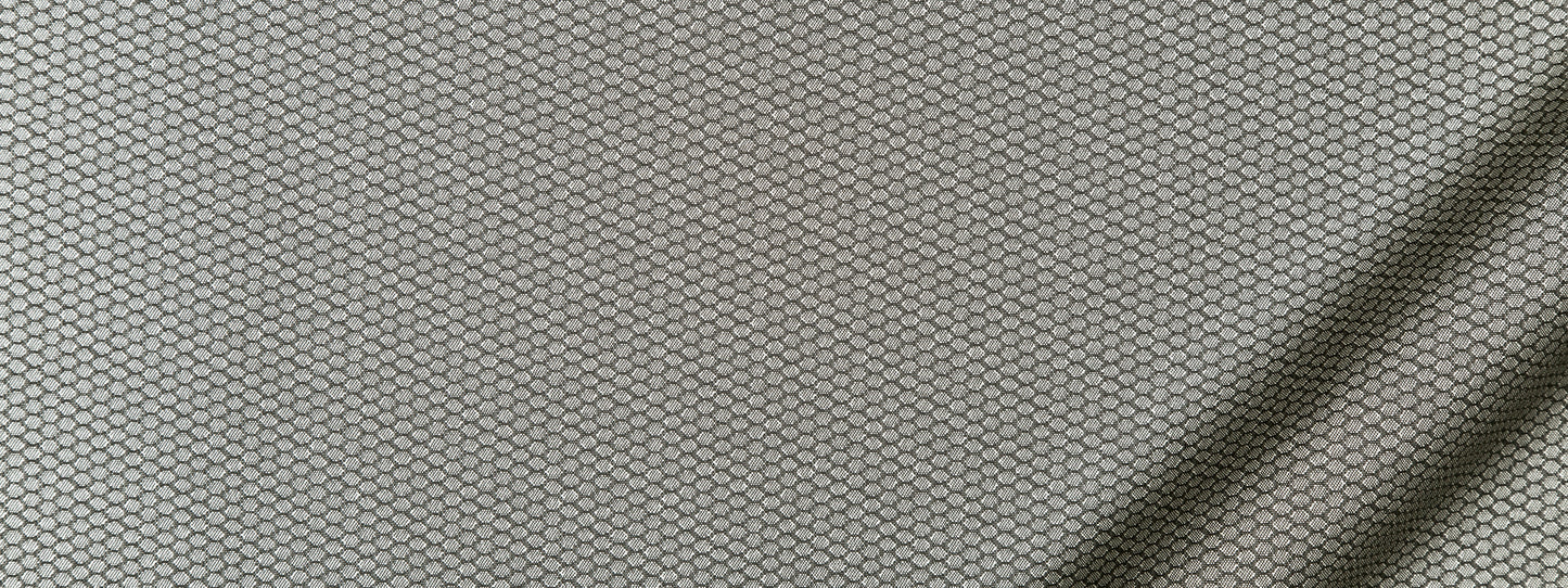 Close-up of light gray upholstery fabric with a subtle honeycomb hexagonal weave pattern.