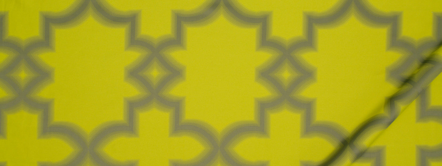 Vibrant citron geometric lattice with interlocking quatrefoil shapes; bold pattern suitable for wallpaper or fabric.