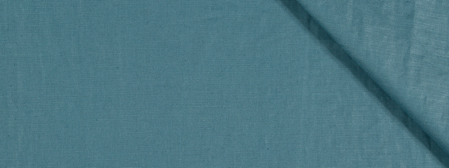 Blue-teal upholstery fabric with visible texture and a diagonal crease/shadow across the upper-right area.