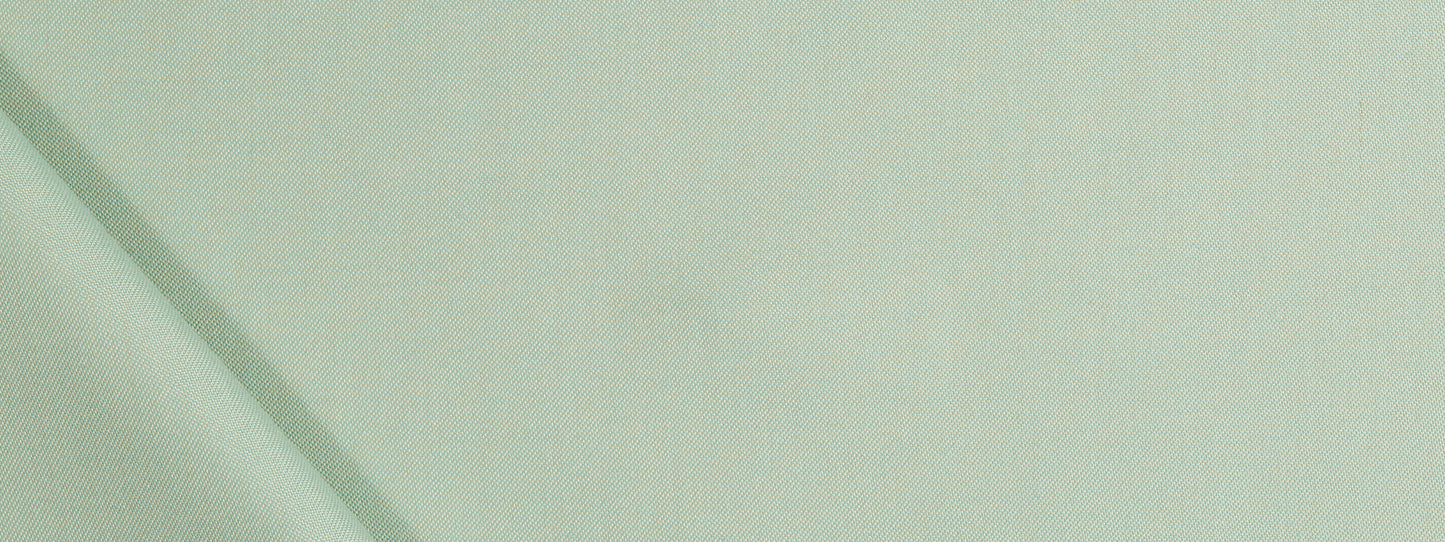 Close-up of pale sage-green upholstery fabric with soft folds and subtle diagonal seam lines.