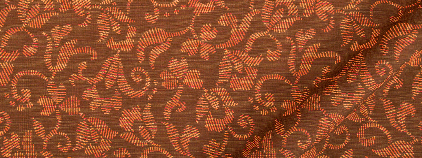 Brown upholstery fabric with orange scroll leaf pattern; woven textile with visible seam.