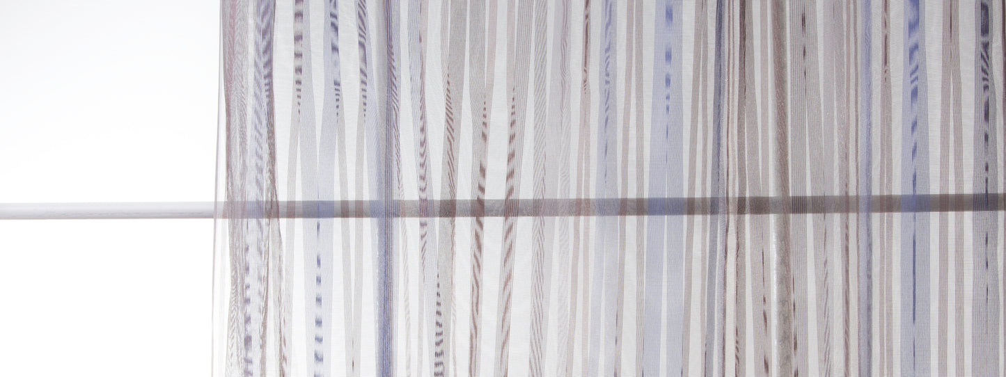 Vertical sheer drapery panels in white and light-gray striped fabric, light-filtering window treatment.