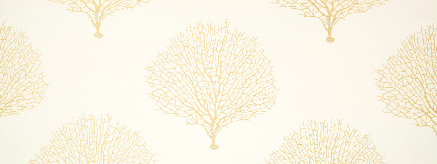 Cream upholstery fabric featuring repeating golden tree-branch motifs for a coastal botanical look.