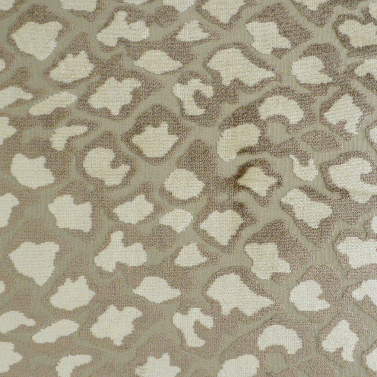 Ivory pillow with a subtle leopard-like animal print; soft textured fabric, 24" x 24
