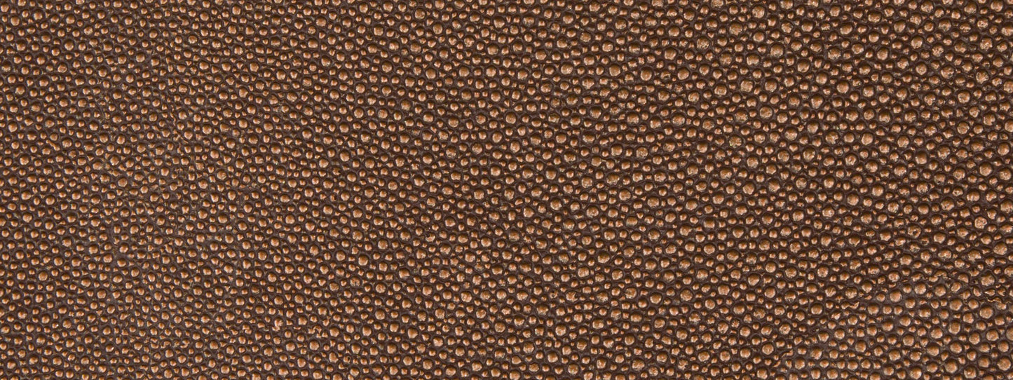 Brown pebbled fabric texture close-up, upholstery fabric with a leather-like grain.