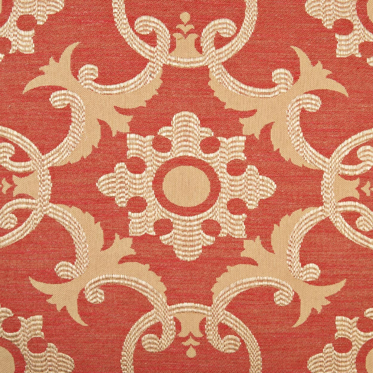 Red damask pillow with cream-beige ornate medallion and scrolling motifs in a repeating symmetrical pattern.