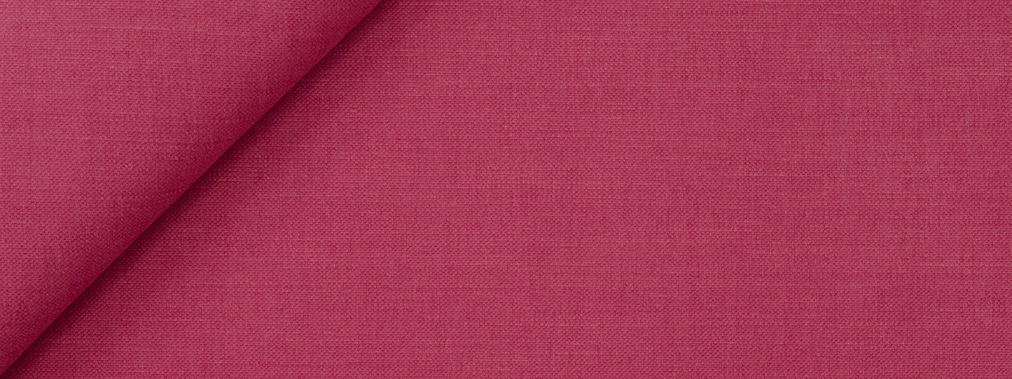 Fuchsia woven upholstery fabric close-up with visible texture and a folded edge