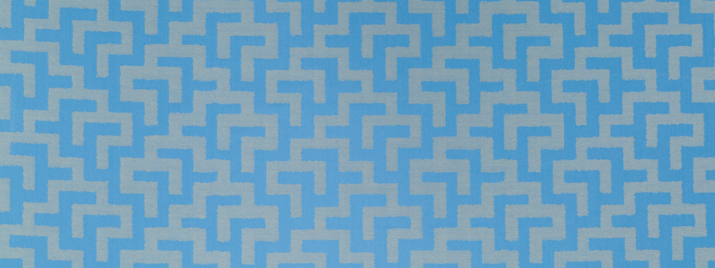 Blue and light-blue geometric maze pattern fabric with interlocking zigzag shapes, modern textile design.