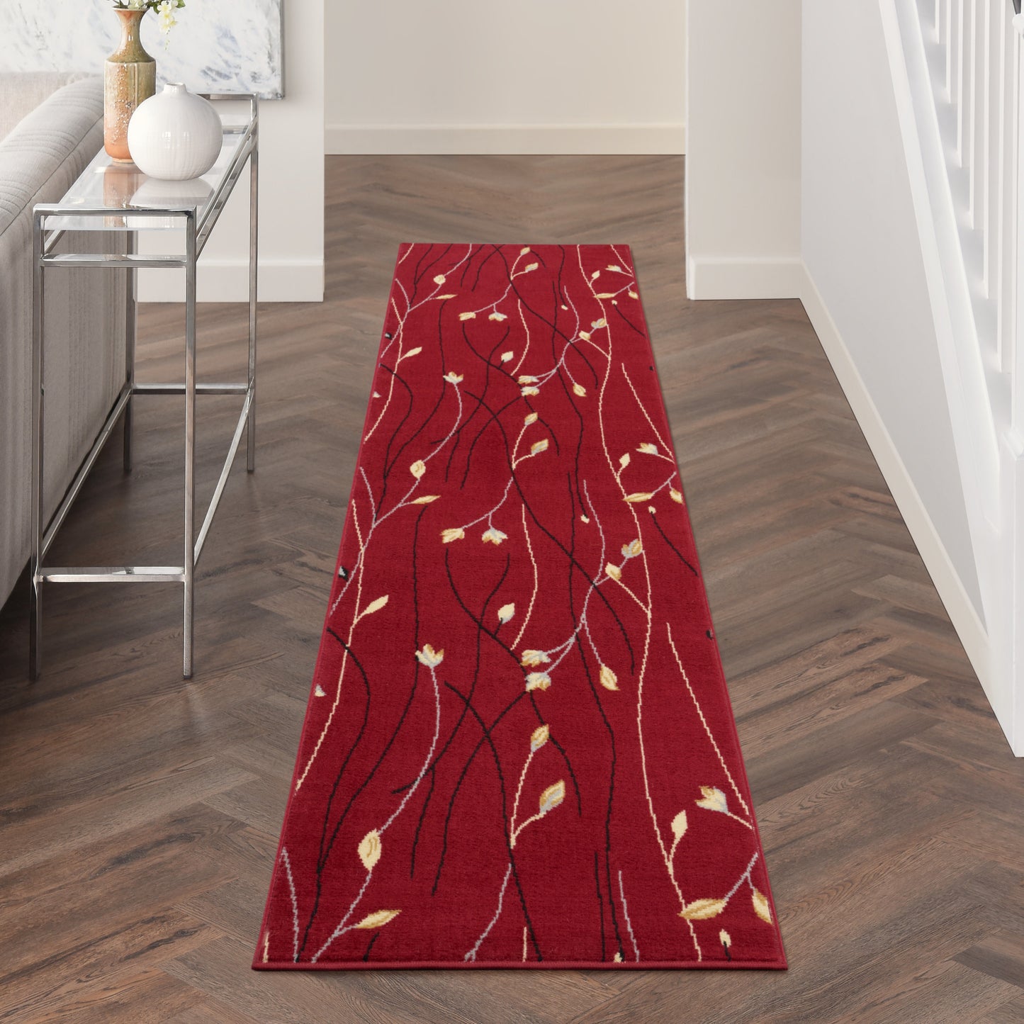 Red hallway runner rug with black and white vine pattern and pale leaf accents; rectangular, ideal for entryways.