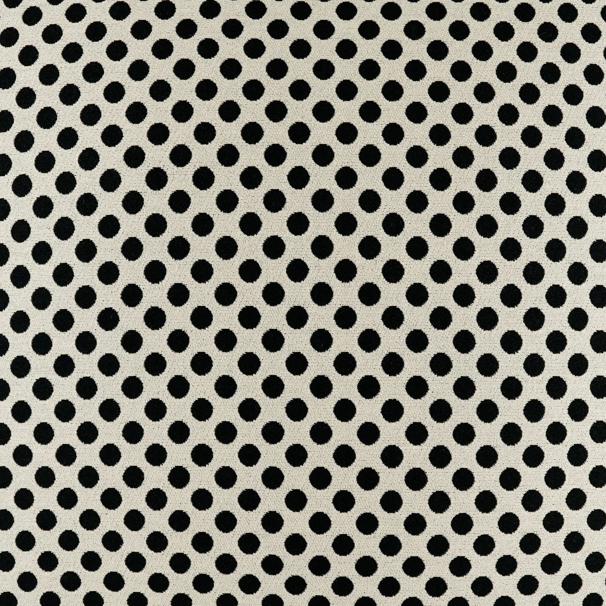 Cream fabric with evenly spaced black polka dots in a classic retro dotted pattern.