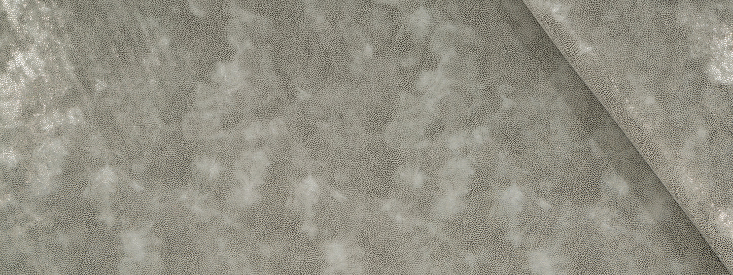 Grey crushed velvet upholstery fabric close-up with a diagonal fold, soft luxurious texture.