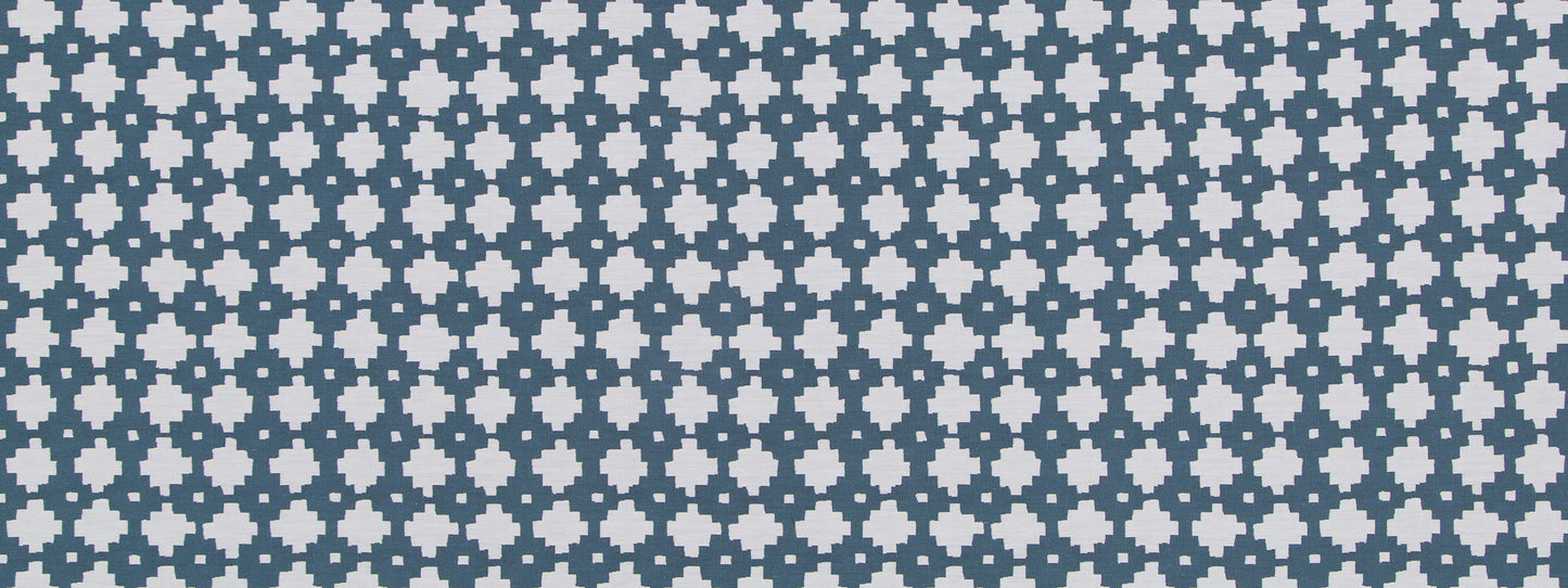 Navy tile with repeating light-blue flower-like quatrefoil motifs in a grid pattern.