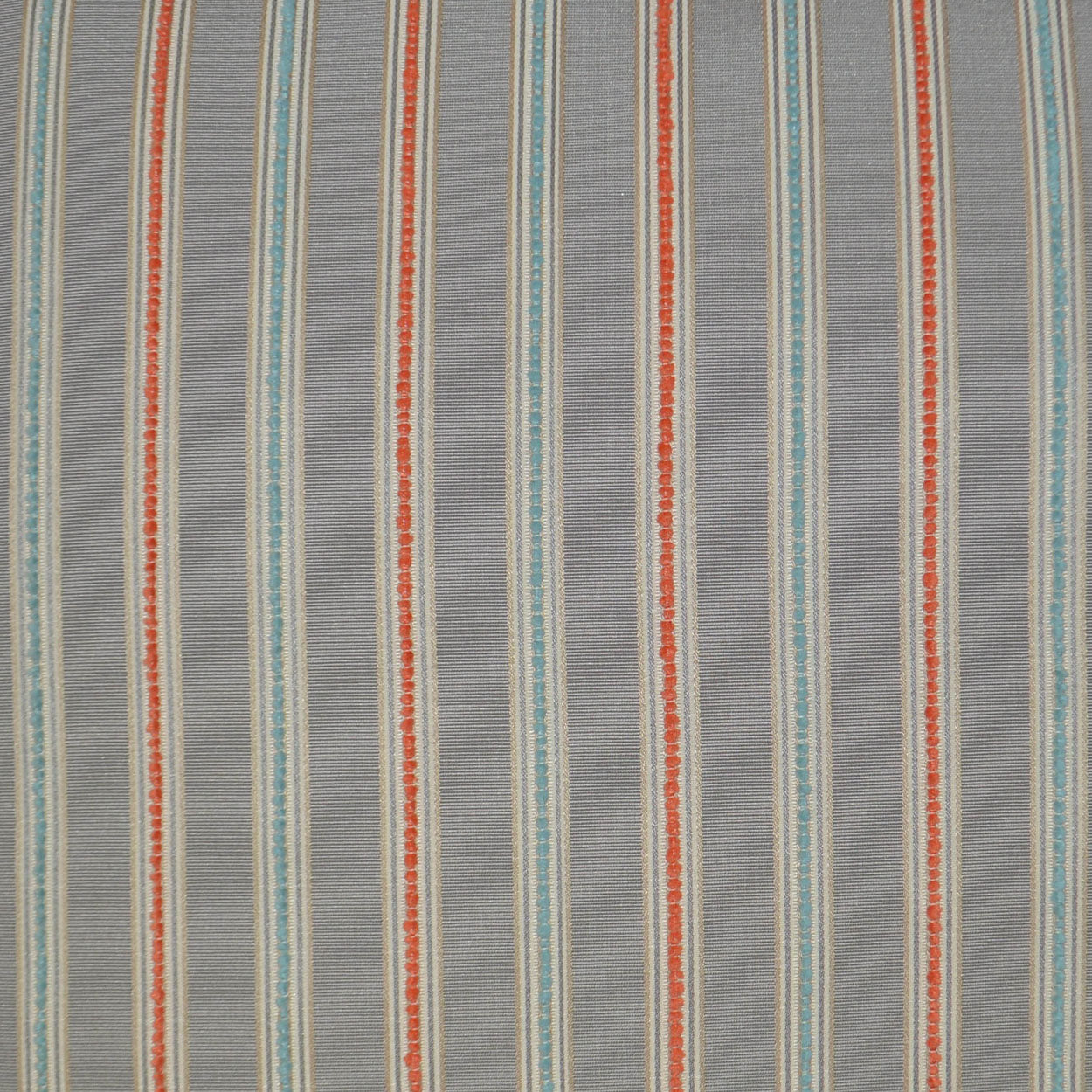 Grey pillow with vertical teal blue & orange dotted stripes.