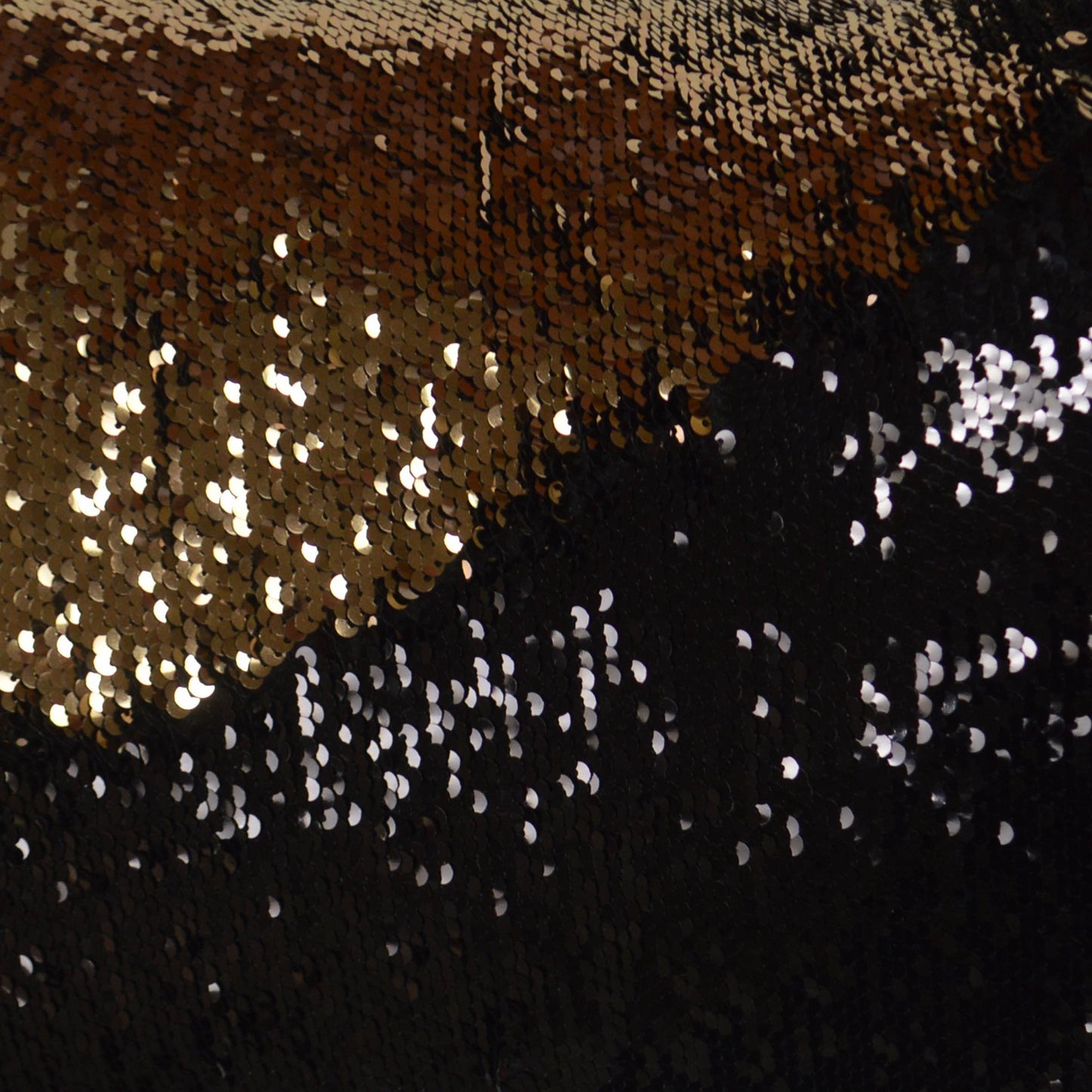 Gold and black sequin fabric with a diagonal color split and shimmering metallic texture for evening wear.