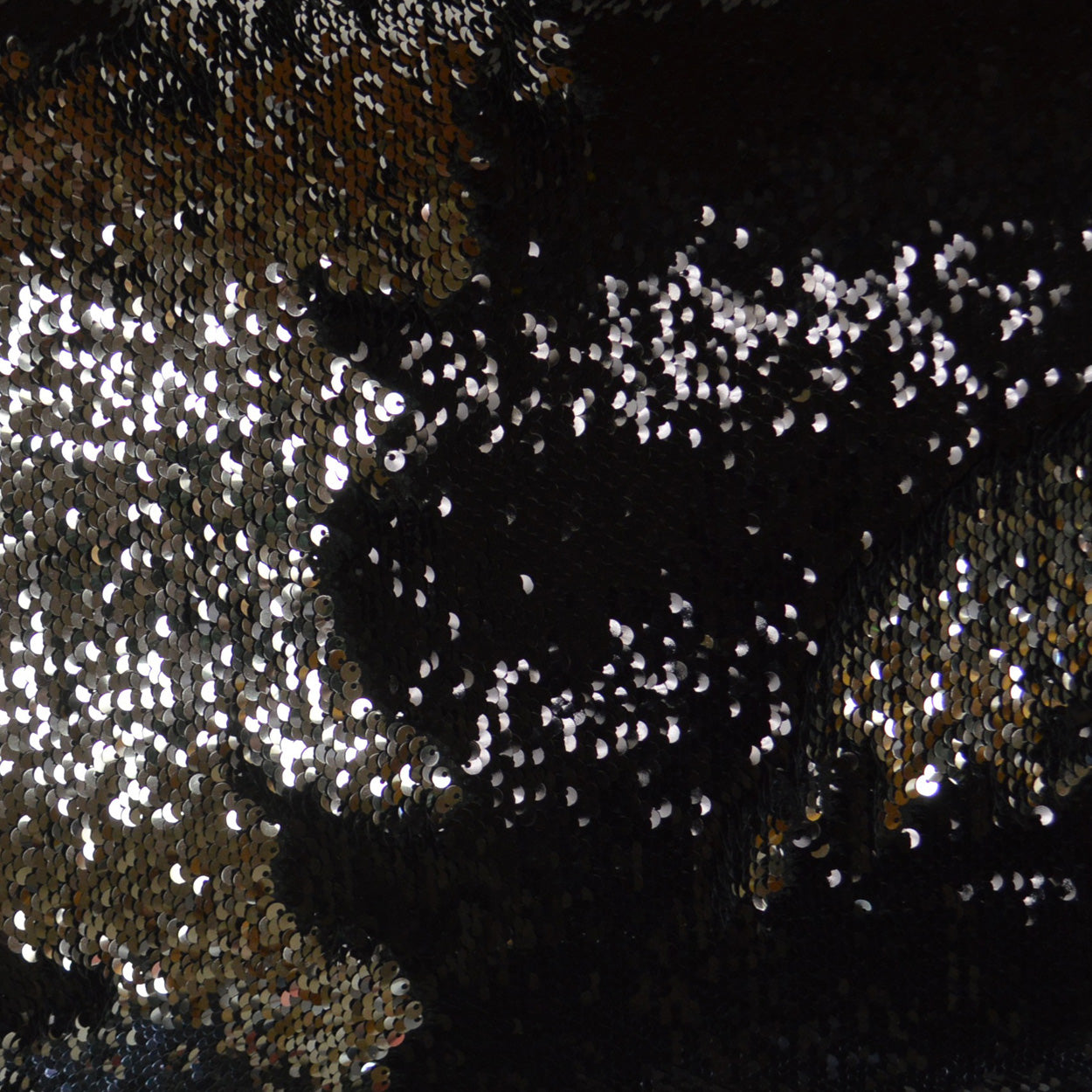 Black sequin fabric with silver & gold reflective sequins; sparkly eveningwear textile.