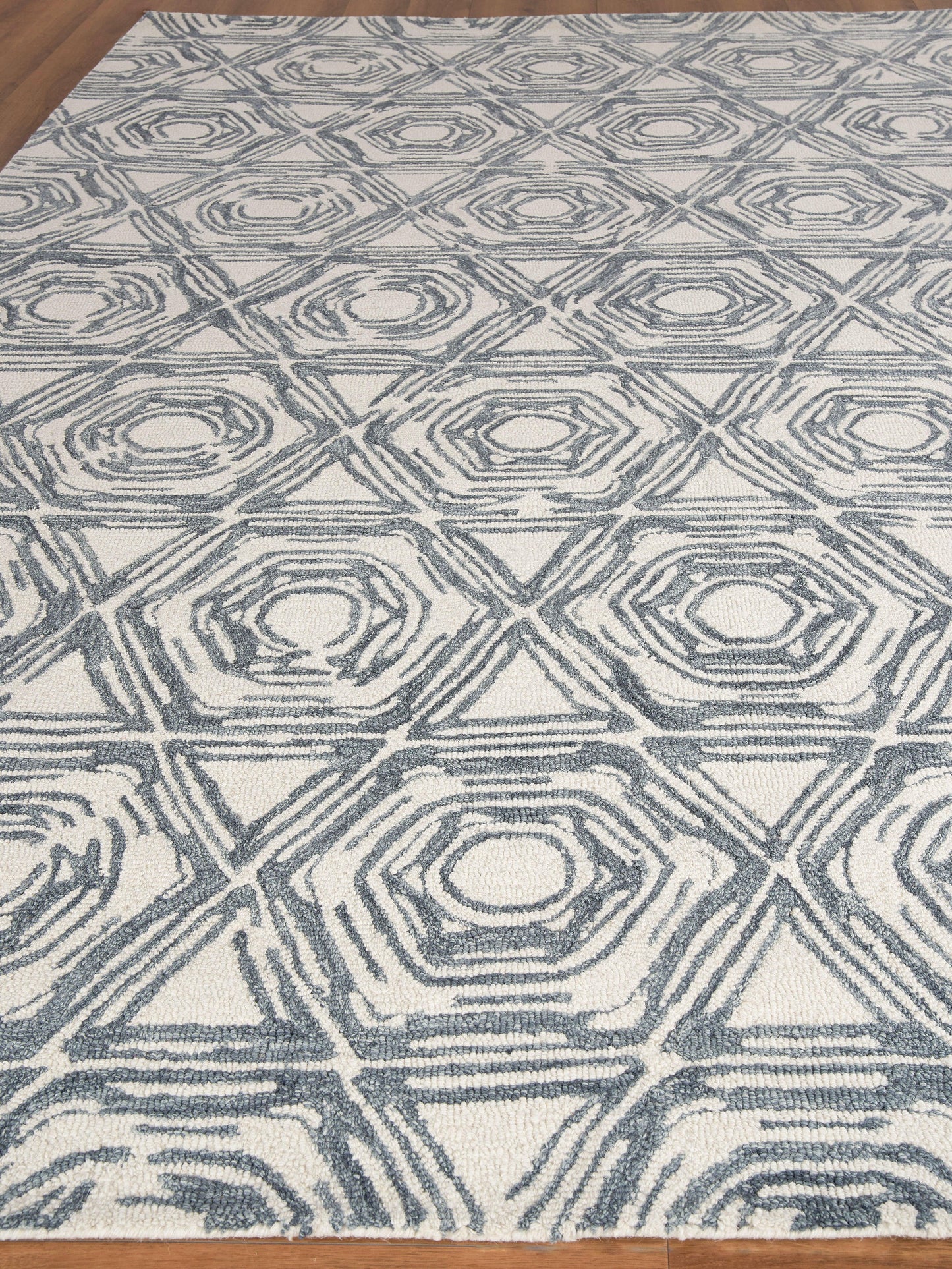 Blue-gray geometric rug with interlocking diamond patterns and concentric hexagon motifs on a cream background.