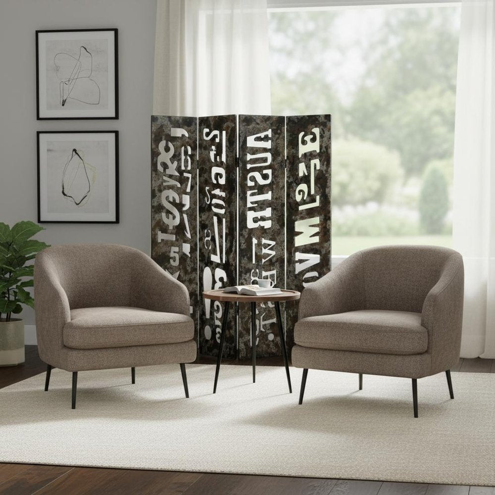 Two taupe mid-century chairs with black legs flank a round wood table; patterned folding screen, art, and sheer curtains.